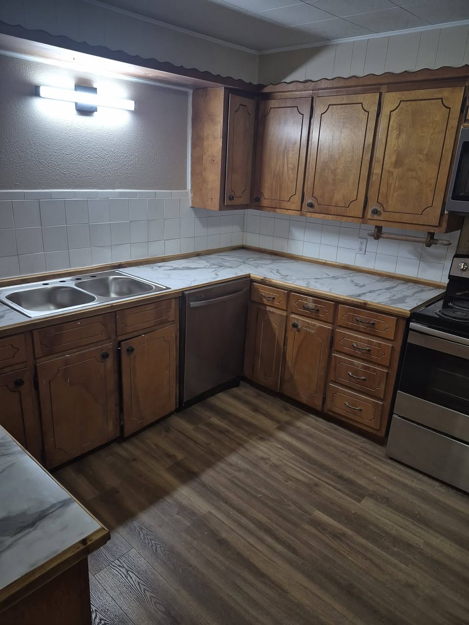 Kitchen remodel showing counters, sink, flooring, and appliances